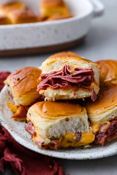 These copycat Arby's beef and cheddar sliders are a must-make for your next gathering. Soft Hawaiian buns topped with sliced roast beef, melty American cheese, onion flakes, and homemade Arby's sauce, brushed with a buttery glaze. Beef And Cheddar Sliders, Arbys Beef And Cheddar, Dinner Potluck, Arby's Sauce, Baked Stuffed Pork Chops, Cooper Kitchen, Roast Beef And Cheddar, Beef And Cheddar, Hawaiian Buns