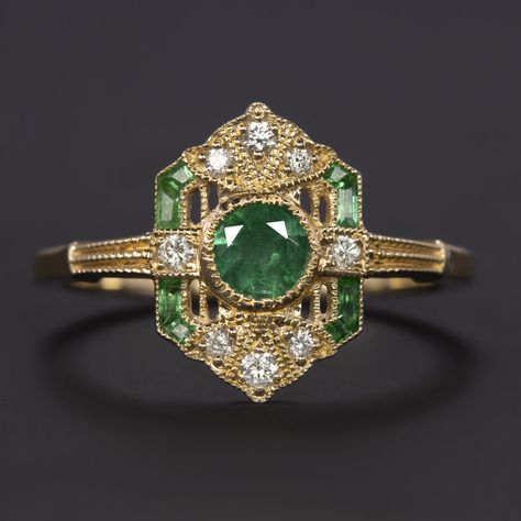 Why we love it:This diamond and emerald ring is beautifully crafted with a geometric Art Deco style design and encrusted with glittering diamonds and spring green emeralds!Highlights:- 0.43ct natural emerald center with gorgeous, well saturated color- Calibre cut natural emerald accents with bright green color- 0.10ct of high quality diamond accents- Unique and elegant vintage style design- 14k yellow gold settingDimensions:13.0mm across (north-south) and 2.9mm from the finger to the top of the ring Gold Emerald Diamond Ring, Green Gemstone Rings, Statement Engagement Ring Unique, Double Emerald Ring, Green Vintage Wedding Ring, Antique Art Deco Ring, Emerald Rose Gold Ring, Unique Engagement Rings Art Deco, Vintage Stone Ring