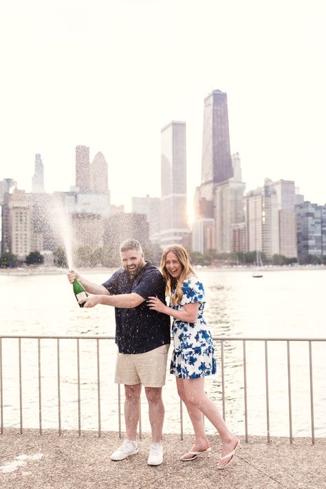 Couple celebrates their summer engagement with champagne by the lakefront in Chicago’s Olive Park with downtown skyline in the background Chicago Downtown, Chicago Summer, Visit Chicago, Summer Engagement Session, Champagne Pop, Surprise Wedding, Navy Pier, Photo Booth Rental, Downtown Chicago