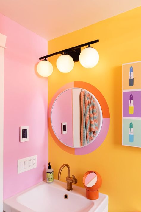 Pink and orange decal around bathroom mirror. Orange And Pink Maximalist, Yellow Orange Bathroom, Pink Yellow Bathroom Ideas, Aesthetic Colorful Bathroom, Pink Orange Yellow Bathroom, Bright Fun Bathroom Ideas, Fun Pink Bathroom, Cute Bathroom Color Schemes, Colorful Bathroom Backsplash