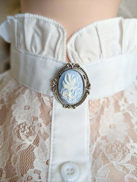 This elegant rose brooch features an ornate vintage-style setting. This beautiful Victorian Jewelry pin features a cameo with a delicate white rose relief on a baby blue background. Size: 1 3/8" (34 mm) long and just over 1 3/16" (30 mm) wide. All metal is plated brass. *Care instructions are simple - Please avoid contact with beauty products/sprays as they can dull the finish. * Ethically Sourced from US & Canadian raw materials * Meticulously handcrafted especially for you! * Arrives in a beau Baby Blue Background, Victorian Accessories, Gifts For History Buffs, Floral Cottage, Rose Brooch, Cabbage Rose, Vintage Inspired Jewelry, Cameo Jewelry, Cameo Brooch