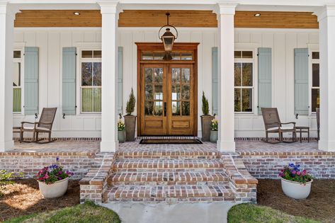 This entryway creates an energy of warmth, elegance, and timelessness as it captures beautiful simplicity of traditional cottage character. From the symmetry to its tall windows and spacious porch, this cottage is endlessly welcoming.   Designed by Bob Chatham Custom Home Design Built by Frostholm Construction LLC Photography by Bailey Chastang Stamped Front Porch, White House Brick Porch, French Country Front Door Ideas, Brick Steps Front Porch, French Country Front Porch Ideas, French Country Exterior Homes, Porch Details, Farmhouse Brick, Country House Exterior