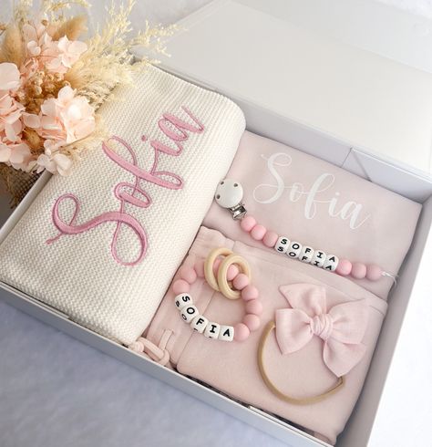 This Personalised Baby Gift Set comes with: 1x Tracksuit Jumper and 1x Tracksuit Pants Knit Blanket with embroidered Name Personalised Teether Personalised Dummy Chain Headband Medium Size Matt White Magnetic Closing Lid Gift Box, With Personalised Name On Lid Gift Box Dimensions: 340mm x 260mm x 90mm Our Personalised Baby Gift Set is a perfect present for a new parent or for your little loved ones. Our gift sets are beautifully and thoughtfully packed in a medium size matt white magnetic closin