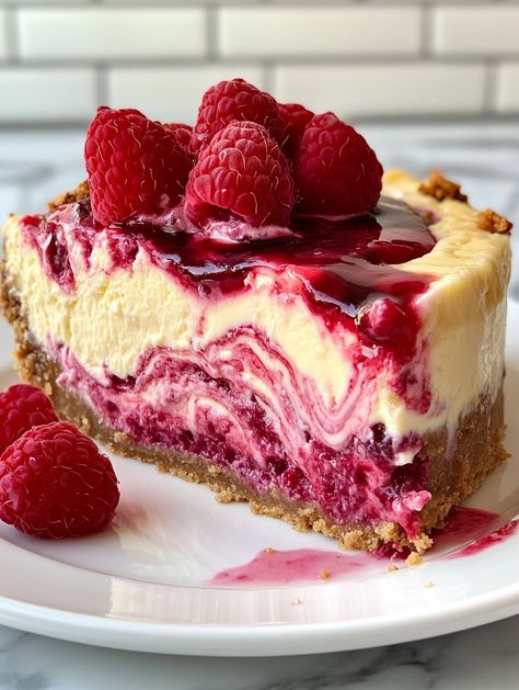 Lemon Raspberry Swirl Cheesecake with a Surprise Center 🍋   𝗜𝗻𝗴𝗿𝗲𝗱𝗶𝗲𝗻���𝘁𝘀 👍  - 2 cups graham cracker crumbs - 1/2 cup unsalted butter, melted - 4 (8 oz) packages cream cheese, softened - 1 1/4 cups granulated sugar - 1 teaspoon vanilla extract - 4 large eggs - 1/2 cup sour cream - 1/4 cup heavy cream - Zest of 2 lemons - 1/4 cup fresh lemon juice - 1/2 cup raspberry jam, warmed - 1 cup fresh raspberries - 1 cup white chocolate chips Fresh Raspberry Desserts, Raspberry Swirl Cheesecake, Swirl Cheesecake, Raspberry Desserts, Fresh Raspberries, Lemon Raspberry, Sweet Snacks Recipes, Raspberry Jam, Cute Desserts