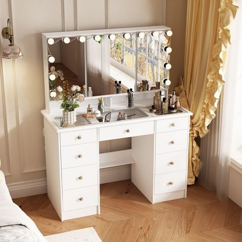 PRICES MAY VARY. Adjustable Mirrors & Hidden Storage - This makeup vanity desk features a large and high-definition mirror that is divided into 3 parts. The mirrors on either side can be opened and adjusted in angle, which will reflect your beauty from different angles and meet your makeup needs. And there are hidden storage shelves behind the 2 side mirrors. Glass Desktop - The vanity desk possesses a spacious glass desktop and 9 drawers to store your cosmetics. The 43.3 inch glass desktop can Dorm Room Vanity Desk, Teen Vanity Ideas, Preppy Vanity, Makeup Vanity With Drawers, Cushion Stool, Vanity Desk With Mirror, Desk With Mirror, Makeup Vanity Desk, Bulb Lights