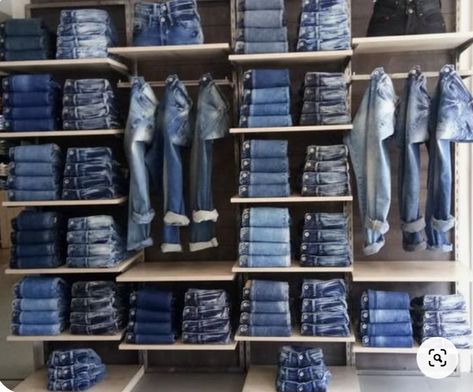 This denim wall is very aesthetically pleasing. They have different colors and styles out that match so well together and stand out against the plain wall and shelves. Jean Display Boutique, Jeans Display Ideas, Small Clothing Store Interior, Denim Wall, Denim Jacket Trend, How To Fold Jeans, Boutique Layout, Denim Display, Fashion Business Plan