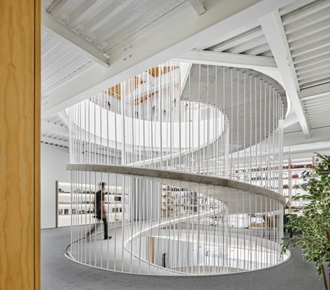 Constructed with formwork on-site, the 4-inch-thick ramp is shaped like an orange peel. In northern Portugal, a sculptural ramp joins two buildings—and two companies—into a cohesive, flexible, future-proof whole by Paulo Merlini Architects. #interiordesign #architecture Spiral Architecture, Ramps Architecture, Ramp Design, Concrete Walkway, Stairs Architecture, Studios Architecture, Spiral Stairs, Ground Floor Plan, Architecture Office