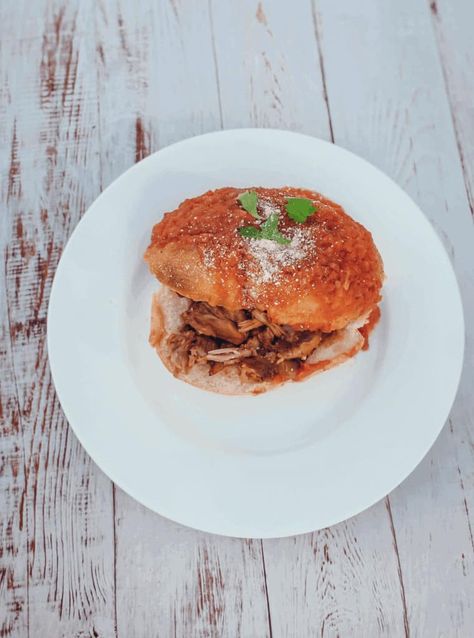 This Tortas Ahogadas dish is made with carnitas, refried beans, hot sauce, hard rolls and dipped in a tomato sauce.  This Tortas Ahogadas dish is famous in the Jalisco region in Mexico. Since my mom is from Guadalajara, we use to eat Tortas Ahogadas frequently. My grandma would stay up all day making the meat and the fresh sauce to pour over the sandwiches. This is why Tortas Ahogadas got its name. Cilantro Parsley, Hard Rolls, Cheesy Zucchini, Cotija Cheese, Roma Tomatoes, Refried Beans, Tomato Sauce, Hot Sauce, Cilantro