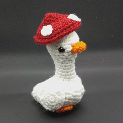 A lovely handmade crochet duck with a mushroom hat that pops up and down when you pull it!  A stuffed animal or plushie that is perfect for any gifting occasion!  This item is 100% handmade by me! due to their handmade nature item may slightly differ from images. Materials: Acrylic yarn, polyester fill, plastic safety eyes Dimensions:  approximately 6.50 inches (16.51 cm) tall, by 3.50 inches (8.89 cm) wide (at widest point), by 4 inches (10.16 cm) in depth (at widest point) Your package will in Crochet Duck With Hat, Mushroom Crochet Ideas, Crochet Pop It, Cute Free Crochet Patterns, Mushroom Hat Crochet, Crochet Mushroom Hat, Red And White Crochet, Mushroom Stuff, Crochet Mushrooms