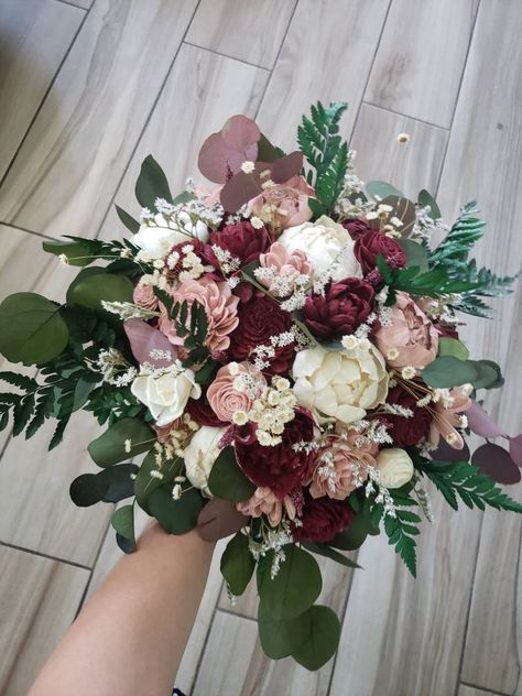 Sola wood flower bohemian style wedding bouquet with dusty rose and burgundy flowers. Greenery is a mixture of artificial and preserved and includes preserved fern, eucalyptus, star flower and german statice. Pictured is the medium 10 inch bridal. Can also be made in smaller and larger sizes. Please see last page for size options. Made to order! Please allow 6-8 weeks for production. Can also add matching bridesmaid bouquets, corsages, boutonnieres, cake flowers, and flower crowns per request. C Marron Flowers Bouquets, Burgundy Wedding Bouquet Bridesmaid, Cinnamon Rose Flower Bouquet, Maroon Rose Bouquet, Burgundy Eucalyptus Wedding, Rose Gold And Burgundy Wedding Flowers, Cinnamon Rose Wedding Bouquet, Burgundy Dusty Rose Bouquet, Navy Blue Dusty Rose And Burgundy Wedding Bouquets