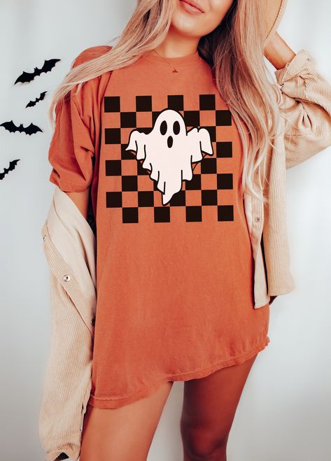 Checker Ghost t-shirt. These tees are Comfort Colors and are made to last using premium ringspun cotton, this creates an vintage-soft shirt. The soft-washed, garment-dyed fabric brings extra coziness to your wardrobe while the relaxed fit makes it an excellent daily choice. ✦ 100% Ringspun Cotton ✦ Color: Grey, Ivory, Yam, Pepper, Orchid, Moss, White ✦ Relaxed fit ✦ Medium fabric ✦ Sewn-in twill label ✦ Eco-friendly, Ethically Made & Sweatshop Free ✦ Printed to order with non-toxic ink ✦ Durable Retro Halloween Shirts, Fall Graphic Tees Trendy, Simple Vinyl Shirts For Women, Halloween T Shirts Design, Cricut Halloween Costume Ideas, Halloween Shirt Ideas For Women, Cricket Ideas Shirts, Vintage Halloween Shirt, Halloween Shirt Ideas Vinyl