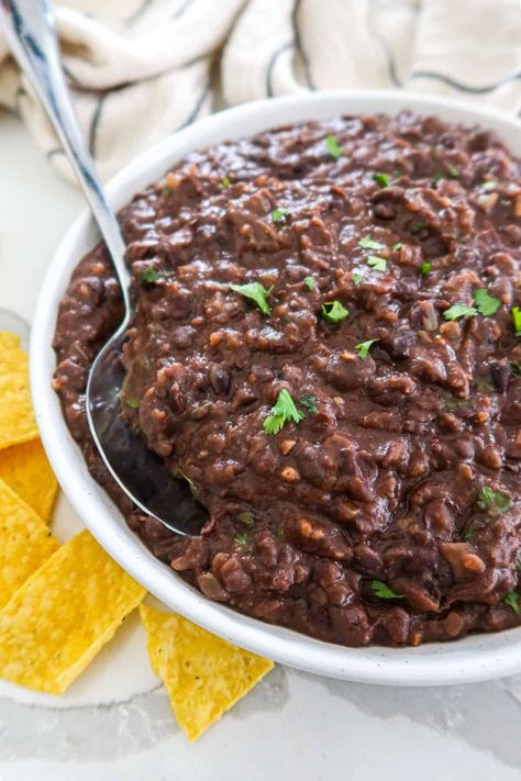 Healthy, homemade refried black beans are delicious, creamy and packed with flavor. This simple side dish pairs seamlessly with all of your favorite Mexican food and also works great as a dip for crunchy tortilla chips! Whip up a batch in 20 minutes with just a handful of ingredients. The easiest Mexican side dish ever! They're even gluten free, vegan, dairy free, vegetarian and high fiber. Refried Beans With Black Beans, Black Bean Refried Beans Recipes, Refried Beans Recipe Canned Black Beans, Black Beans Canned Recipes, Black Beans Mexican Style, Refried Black Beans From Can, Black Beans Mexican, Refries Black Beans Recipe, Refried Black Beans Recipe