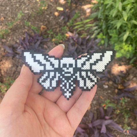 Skull moth made from mini perler beads! (can be made into keychain/necklace/earrings, DM on instagram @feastoncreations to request) Perler Bead Skull Patterns, Pentagram Perler Beads, Perler Bead Patterns Space, Enderman Perler Beads, Pearler Bead Halloween Patterns, Slipknot Perler Beads, Hockey Perler Beads, Icp Perler Bead Patterns, Cryptid Perler Beads