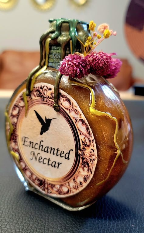 Step into the mystical realm with our Enchanted Nectar Potion Bottle - a glass-crafted masterpiece that transcends the ordinary. Meticulously handcrafted with an unwavering attention to detail, this bottle is not just an accessory; it's a bewitching fusion of witchy charm, boho elegance, and earthy allure designed to elevate your home decor. The Enchanted Nectar Potion Bottle beckons with its entrancing design, featuring an exquisite blend of botanical and floral elements. Crafted with a touch of magic, this bottle captures the essence of an otherworldly elixir, bringing a sense of enchantment to any space. Designed for those who embrace the unconventional and appreciate the ethereal, this potion bottle is a unique statement piece. With crystals carefully embedded within, it creates a mesm Potion Maker Character Design, Witch Potions Aesthetic, Weird Bottles, Witchy Potion Bottles, Truth Potion, Witch Potions, Vintage Glass Bottles, Bristol Tn, Witchy Boho