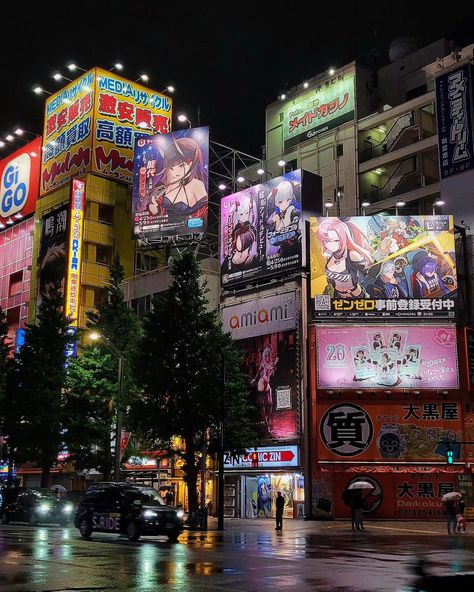 Have you visited Akihabara in the rain at night yet? Akihabara, aka Akiba, is the anime otaku district of Tokyo Japan. The neon lights and anime billboards always look the best on a rainy night. Most of the anime figure stores are closed at night, but the arcades, games centers, and maid cafes are still open. It's also a great time to try to spot some itasha Tokyo Night Anime, Japan At Night Aesthetic, Anime In Japan, Store At Night, Japan At Night, Neon Japan, Buildings At Night, Rain At Night, Tokyo At Night