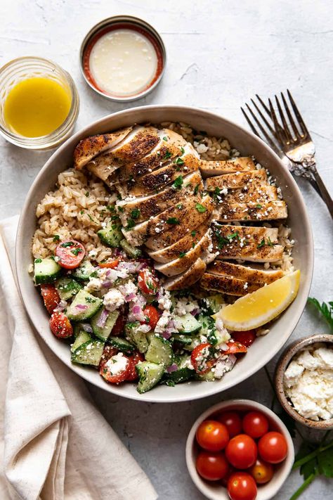 These greek chicken bowls are an easy and healthy summer dinner. Tender greek seasoned chicken and fluffy brown rice are served with an english cucumber salad made up of cherry tomatoes, feta cheese, red onion, parsley and a homemade vinaigrette. English Cucumber Salad, Fluffy Brown Rice, Greek Bowls, Cherry Tomatoes Feta, Greek Chicken Bowls, Healthy Summer Dinner, Greek Spices, Homemade Vinaigrette, Chicken Over Rice