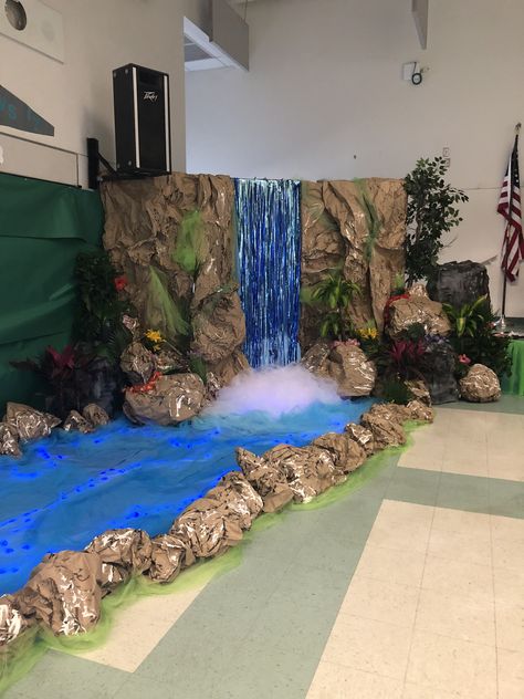 DIY Waterfall Waterfall Dramatic Play, How To Make A Waterfall Out Of Paper, Fake Waterfall Decoration, Madagascar Decorations Diy, Waterfall Decoration Ideas, Waterfall Set Design, Vbs Waterfall Decorating Ideas, Waterfall Decoration Indoor, Waterfall Diy Decoration