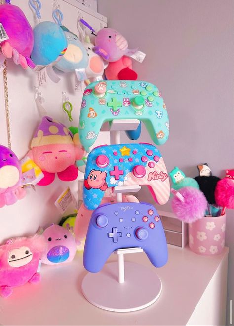 Its the little things. This is so cute for displaying all your cute controllers! #gamergirl #gamersetup #gamergirlsetup #kawaii #pastelgoth #pastelcore #pastelgamer #nintendoswitch #gamer #gamerneeds #organizedhome #kirby Cute Game Controller, Kawaii Gamer Setup, Xbox Setup Ideas, Kirby Gaming Setup, Xbox Controller Aesthetic, Kawaii Gamer Aesthetic, Xbox Gaming Setup, Controller Display, Gamer Headset