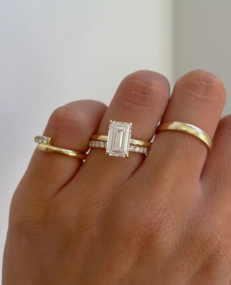 A stunning emerald cut solitaire engagement ring paired with a classic pave wedding ring. Emerald Simple Engagement Rings, Simple Gold Engagement Rings Emerald, Wedding Bands Emerald Engagement Ring, Tapered Emerald Cut Engagement Ring, Emerald Cut Engagement Ring Gold Halo, Emerald Ring And Band, Vintage Emerald Cut Engagement Ring With Band, Emerald Cut Engagement Ring With Infinity Band, Emerald Cut Stacking Ring