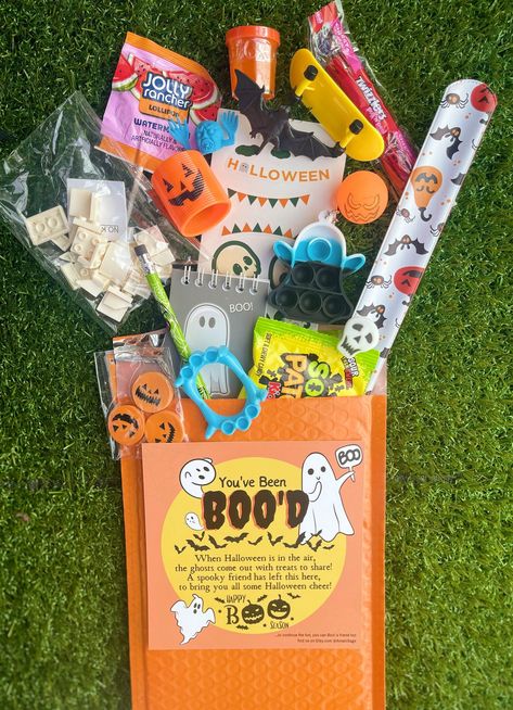 You've been Boo'd Gift Bags come in a 6x10 bubble mailer filled with a mystery variety of fidget toys, candy, Halloween classic trinkets, and a "You've Been Boo'd" card that you can leave a personal message. This is the perfect trick or treat gift to send or even surprise yourself.  FAQ  What does "You've Been Boo'd" mean?  🎃 A Halloween boo is a small gift or treat left anonymously by a friend, family, or neighbor!  Have a little ghoul or goblin you are wanting to surprise this Halloween?!  🎃 Send them a Boo Bag! We can keep it a secret between the two of us or you can reveal who you are with a personalized note.  What's in the Boo Bag? 👀 🎃 A Boo Bag arrives in a 6 x 10 bubble mailer that contains a card informing the receiver that "THEY'VE BEEN BOO'D" alongside about 12 - 15 mystery Boo Bags Halloween, Boo Bags, Youve Been Bood, Mini Boo, Boo Baskets, Boo Boo Bags, Halloween Mystery, Halloween Goodie Bags, Candy Halloween