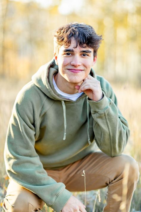 Senior boy kneels and rests his face on his hand and smiles surrounded by aspens during the fall during his senior session in Cripple Creek, Colorado with Eden's Glow Photography. Senior Picture Ideas For Guys Nature, Fall Senior Boy Picture Ideas, Senior Mini Sessions, Outdoor Male Senior Pictures, Boy Senior Photos Nature, Boys Outdoor Senior Picture Ideas, Boys Senior Picture Ideas Soccer, Senior Fall Pictures Boys, Fall Senior Photos Boys