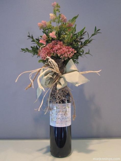 A nice bottle of wine is always a perfect gift for a host or hostess. We have all seen the velvet wine bags sold in stores these days - they're nice, but they lack individuality. Even worse are the plastic or foil bags that your liquor store will offer. Don't do it! A few years ago, I created a wine bouquet that can be wrapped around any bottle of wine, which I use when bringing wine as a gift. It takes a little time, but people do stop and notice this charming way of presenting a bottle of ... Wine Gift Box Ideas, Wine Bottle Flowers, Bottle Gift Wrapping, Wine Bottle Centerpieces, Wrapped Wine Bottles, Bridal Shower Wine, Bottle Ideas, Bottle Diy, Wine Bags