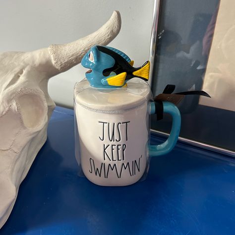 Rae Dunn Disney Pixar Finding Nemo Dory Just Keep Swimmin’ Topped Mug White Mug With Blue Handle. The Words Just Keep Swimmin’ Are Written In The Signature Rae Dunn Font. The Mug Has Dory On Top Of The Lid. Brand New With Tags! Dishwasher Safe. Rae Dunn Is Known To Be Perfectly Imperfect So There May Be Small Blemishes. Check Out My Other Listings For More Disney Rae Dunn Items! Rae Dunn Font, Disney Kitchen Decor, Ray Dunn, Rae Dunn Disney, Nemo Dory, Rae Dunn Collection, Disney Kitchen, Disney Mugs, Finding Dory