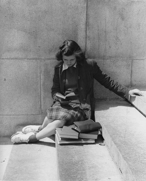 Student, dressed for class, reading on steps, 1950s.“I am reading six books at once, the only way of reading; since, as you will agree, one book is only a single unaccompanied note, and to get the full sound, one needs ten others at the same time.” ― Virginia Woolf, The Letters of Virginia Woolf: Volume Three, 1923-1928 Foto Portrait, Black And White Photograph, Woman Sitting, Lukisan Cat Air, Woman Reading, Foto Vintage, Reading A Book, Girl Reading, 인물 사진