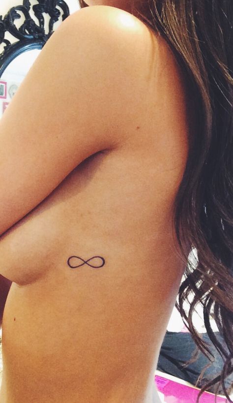 Small and simple infinity tattoo Infinity Tattoo Rib Cage, Tattoo Ideas Female Small Infinity, Small Infinity Wrist Tattoos For Women, Minimal Infinity Tattoo, Infinity Rib Tattoo, Infinity Tattoo Placement, Infinity Small Tattoo, Small Tattoos Easy To Hide, Fine Line Infinity Tattoo