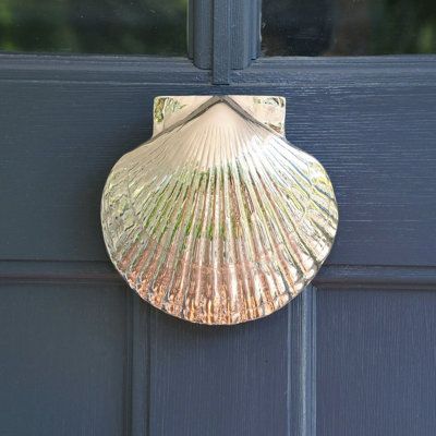 Nature's beautiful design, the Scallop shell has many lines that radiate from a single point. The Scallop is a good reminder that home may be the starting point for all your life's adventures. Perfect for a coastal home or beach house! | Michael Healy Scallop Door Knocker Gray 4.5 x 4.5 x 1.5 in | MHS32 | MHDE1211_55262016_55262019 | Wayfair Canada Seashell Door Knocker, Cute Door Knocker, Hampton House Decor, Scallop Shell Door Knocker, Cape Cod House Decor, Coastal Cottage Entryway, Funky Beach House, Small Beach House Exterior, Coastal Home Aesthetic