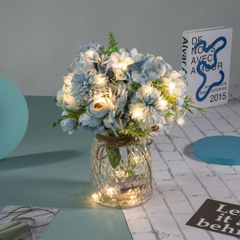 PRICES MAY VARY. PACKAGE - Including LED lights, 3 aritficial Blue Rose Bouquets and a Glass Vase. Total height is about 13”/33CM. Vase height is 6.3"/16CM. Flower height is about 13”/33CM. CREATIVE LED DECORATION - This Table LED flowers is perfect for your wedding, party, baby shower or home decor, etc. EASY TO SET UP- Put half of the led lights in the vase, and wrap the rest around the fake flowers. The LED lights have 8 remote control mode. LIGHT UP YOUR LIFE - The entire flowers and vase ar Artificial Flower Arrangements Centerpieces, Sweet 16 Centerpieces, Blue Sweet 16, Mesas Para Baby Shower, Blue Wedding Centerpieces, Blue Wedding Decorations, Centerpiece Home, Blue Centerpieces, Lighted Centerpieces