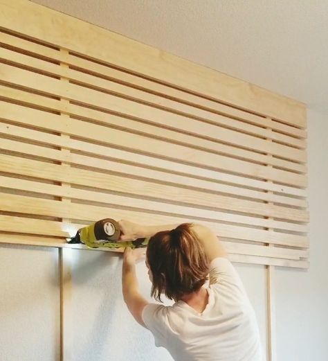 This slat accent wall   headboard is super affordable and an easy DIY project done in just a few hours.  Instructions:  Find the studs you’re going to attach the eight-foot vertical boards to. The studs were four feet apart which means there will be a foot of the horizontal board hangover on each side. Our bedroom ceilings are nine feet tall so I had to cut two, one-foot pieces from the third board. Use wood screws to attach the vertical boards that go from floor to ceiling.  Start at… Interesting Bedroom Walls, Accent Wall Headboard Wood, Horizontal Slatted Wall, Bed Accent Wall Ideas, How To Do A Slat Wall, Bohemian Bedroom Accent Wall, Horizontal Slat Headboard, Decorative Slat Wall, Horizontal Wood Wall Interior