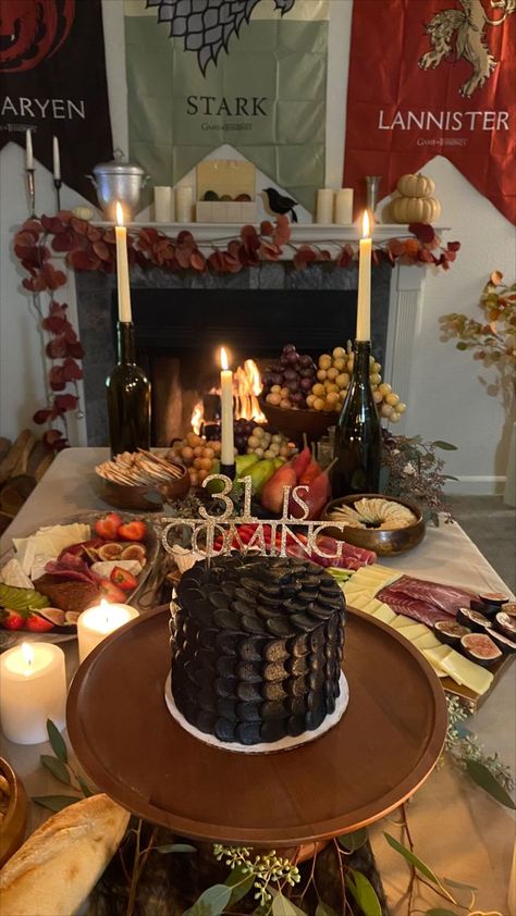 Game of Thrones Birthday Theme Party. I threw my own 31st birthday party and decided on GOT. I custom ordered this dragon scale cake and etsy ordered the cake topping that reads "31 is coming". Did a great food theme of a whole chicken roast, sour breads and cheese platter. Drank red wine and lit candles. Also had the fireplace going with GOT episodes playing in the background. Game Of Thrones Birthday Decorations, Game Of Thrones Themed Food, House Of Dragons Party, Game Of Thrones Party Food, Game Of Thrones Themed Party, House Of The Dragon Watch Party, Game Of Thrones Birthday Party Ideas, Game Of Thrones Party Ideas, House Of The Dragon Party