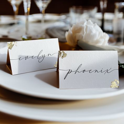 "This unique folded place card design features an elegant lettering with imitation gold flakes on the edges. These place names are the perfect wedding decor for finishing off your table setting for your wedding or other special occasion. The personal names are printed and the gold flakes are applied by hand. You can order two different sizes: EU size (90x55mm) or US size (3.5\"x 2\"). In the note to the seller at checkout, please provide me with the names for the place cards.  Our time frame for processing is 1-3 working-days plus shipping time. ----- Placecard Wedding, Gold Flakes, Weddingdecor, Dining Table Setting, Imitation Gold Leaf, Rehearsal Dinner, Place Names, Personalized Names" Place Card Design, Elegant Lettering, Dinner Place, Wedding Gold, Paper Place, Place Names, Wedding Places, Gold Flakes, Wedding Invitation Paper