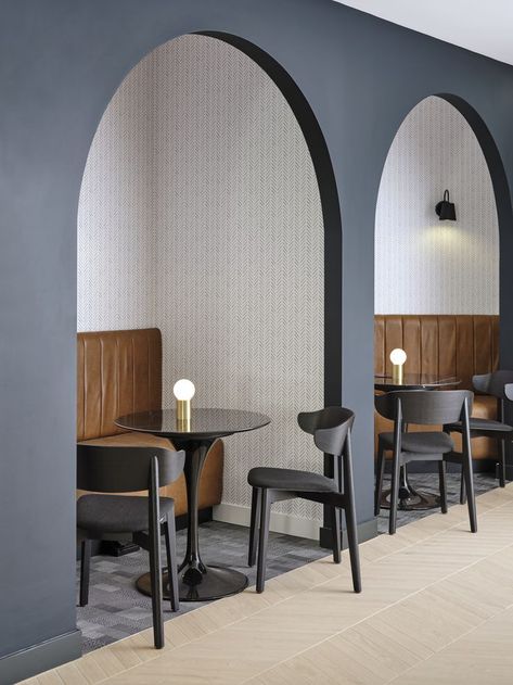 Leather banquette seating within an arch. Small round black table in front with two black chairs. Tiled floor outside of the arch and Bolon inside. Arch Booth Seating, Arch Interior Design Restaurant, Arch Office Interior, Wall Booth Seating, Office Booth Seating Design, Booth Seating Office, Curved Booth Design, Cafe Booth Seating Design, Wall Seating Design