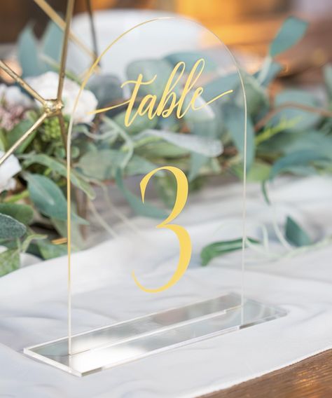 PRICES MAY VARY. ➡️ 𝑮𝑼𝑬𝑺𝑻𝑺 𝑾𝑰𝑳𝑳 𝑭𝑰𝑵𝑫 𝑻𝑯𝑬𝑰𝑹 𝑺𝑬𝑨𝑻𝑺 𝑭𝑨𝑺𝑻: These table number signs are designed with big, beautiful Gold font, so everyone can spot their table, even from far away; With our wedding table numbers, guests won't be wandering around the venue looking lost ➡️ 𝑭𝑰𝑻𝑺 𝑨𝑵𝒀 𝑬𝑽𝑬𝑵𝑻, 𝑰𝑵𝑺𝑰𝑫𝑬 𝑶𝑹 𝑶𝑼𝑻𝑺𝑰𝑫𝑬: The wedding table number sign set comes with large, sturdy bases and double-sided nano stickers (for outdoor use); You can use the table mark Fall Table Number Ideas, Clear Table Numbers, Table Assignments Wedding, Wedding Table Number Ideas, Table Signs Wedding, Acrylic Table Numbers Wedding, Head Table Sign, Wedding Decor Gold, Gold Table Number