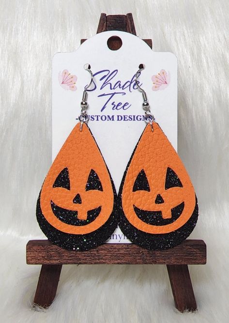 "Halloween Jack-O-Lantern faux leather and glitter earrings! Two layer teardrop earrings featuring either cute or scary black glitter face on orange faux leather with a black glitter bottom layer. Standard size: 2\" length, 1.3\" wide, 2.75\" drop Petite size: 1.5\" length, 1\" wide, 2.25\" drop" Leather Holiday Earrings, Holiday Faux Leather Earrings, Cricut Halloween Earrings, Halloween Faux Leather Earrings, Fall Leather Earrings, Faux Leather Earrings Template Free, Faux Leather Earring Ideas, Diy Halloween Earrings, Cricut Earrings Diy