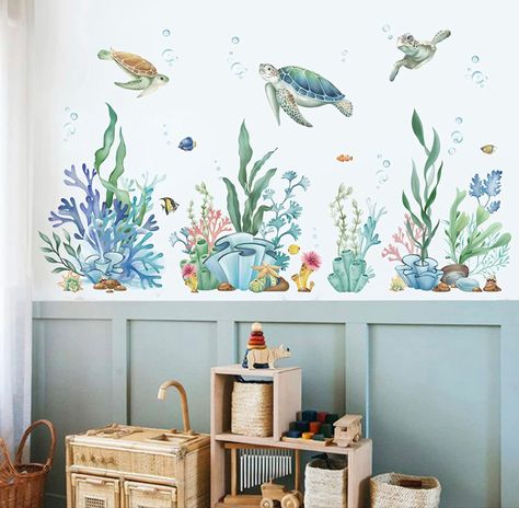 A blue nursery with ocean theme wall stickers on the wall. Coral Reef Themed Bedroom, Ocean Wall Stickers, Ocean Gender Neutral Nursery, Under The Sea Wall Decals, Underwater Nursery Theme Girl, Under The Sea Bathroom Ideas Kids, Under Water Nursery Theme, Aquarium Nursery Theme, Under The Sea Toddler Room