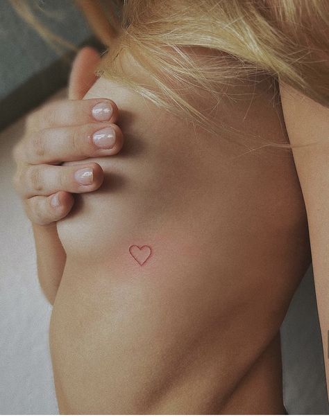 Micro Red Heart Tattoo, Red Tattoo Ribcage, Small Red Heart Tattoo On Chest, Tattoo Over Heart Placement, Small Red Heart Tattoo On Buttcheek, Heart Ribcage Tattoo, Hidden Heart Tattoo, Small Heart Tattoo Placement, Heart Tattoo Ribcage