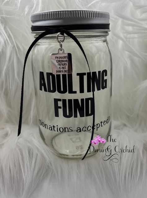 "Who said adulting was easy? This cute jar will remind you to drop your change or spare bills in it and make saving a little more fun. It might even entice your guests to make a donation 😊 Clear glass Jar is 16 ounce size, approximately 3\" in diameter and 5\" tall with silver color screw on lid with slot. Your choice of ribbon colors, pictured with black ribbon and stainless steel charm that reads \"my favorite childhood memory is not paying bills\" This item can be personalized, If requesting personalization please add it in the notes section. Now available in quart size jars!" Money Saving Jars Ideas Diy, Cute Tip Jar Ideas For Work, Disney Savings Jar, Welcome To Adulthood, Goth Apartment, Disney Savings, Jar Decorations, Money Saving Jar, Change Jar