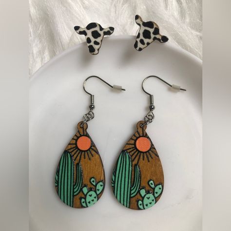 Two Pairs Of Statement Costume Jewelry Earrings. One Pair Of Drop/Dangle Wooden Earrings With A Cactus And Sun Design. Silver Tone Hardware. One Pair Of Cow-Print Wooden Stud Earrings. Western Vibes. Super Cute! A Great Gift For A Country Friend!Message Me And I’ll Wrap It Nicely And Include A Personalized Note! New/Never Used Or Worn. Have A Nice Day! Wood Burnt Earrings, Fall Wooden Earrings, Wood Burned Earrings, Cow Print Earrings, Hair Earrings, Wood Burn Designs, Earrings Western, Western Vibes, Wood Earring