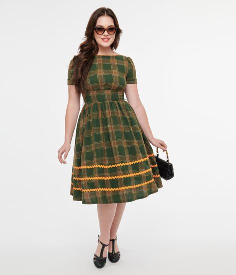 This beautifully 1950s woven dress showcases a vibrant green plaid that will make you feel like a breath of fresh air. The delicate orange ric rac detailing adds an extra touch of elegance, while the included white belt cinches your waist for a flattering silhouette. You'll love the sweet surprise of white faux bows on the back, adding a playful twist to your look. The scoop neck and convenient back zipper ensure comfort without sacrificing style.Available in sizes XS-5X while supplies last. Retro Dresses 50s, Faux Bows, Christmas Dress Women, Vintage 1950s Dresses, Chevron Dress, Ric Rac, White Belt, Retro Women, 1950s Dress