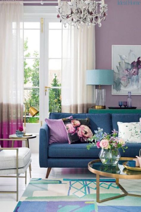 Give your living room a feminine update with a punchy purple decorating scheme. We’re not talking about decorating your living room with fierce, power-glam purples we all loved a few years ago, but a softer and easier plum that walks the line between feminine and masculine for an elegant feel you can take in any direction, from shabby chic to smart and contemporary. Just team your purple living room with the right neutral and be fearless with accents. #decoratingtips #purpleroomideas #livingroom Purple Living Room Furniture, Purple Living Room Ideas, Purple Living Room, Furnitur Ruang Keluarga, Boho Interior Design, Blue And, Living Room Color Schemes, 패턴 배경화면, Colourful Living Room