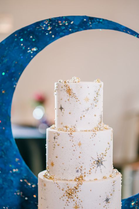 Behold a constellation of sweetness! This celestial-inspired wedding cake is truly out of this world. Adorned with golden stars and glittering accents, it's a heavenly centerpiece for a couple's Starry Night theme. Cake: The Cakewalk Shop Planner: It's all in the Details, Emily Bernard Photographer: B. Jones Photography #StarryNightWedding #WeddingCake #CelestialLove #StarryNightWedding #WeddingCake #CelestialLove #weddingsinwoodinville Wedding Cake Star, Moon And Star Wedding Cake, Wedding Cakes Celestial, Celestial Themed Wedding Cake, Autumn Celestial Wedding, Wedding Cake Stars, Night Sky Wedding Cake, Wedding Moon Theme, Wedding Starry Night