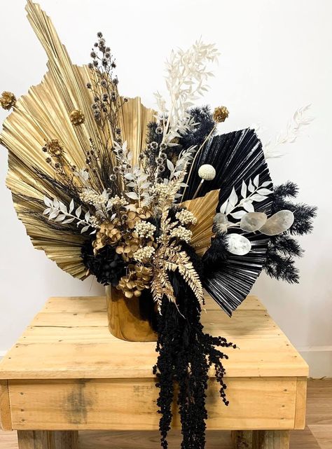 Incorporate the beauty of nature into your black and gold wedding décor by incorporating stunning floral arrangements. Envision lush white blooms elegantly contrasted against rich black vases, adorned with touches of gold for a touch of opulence. Alternatively, consider incorporating feathers or dried grains into your arrangements, adding a touch of organic elegance that perfectly complements the regal color palette.