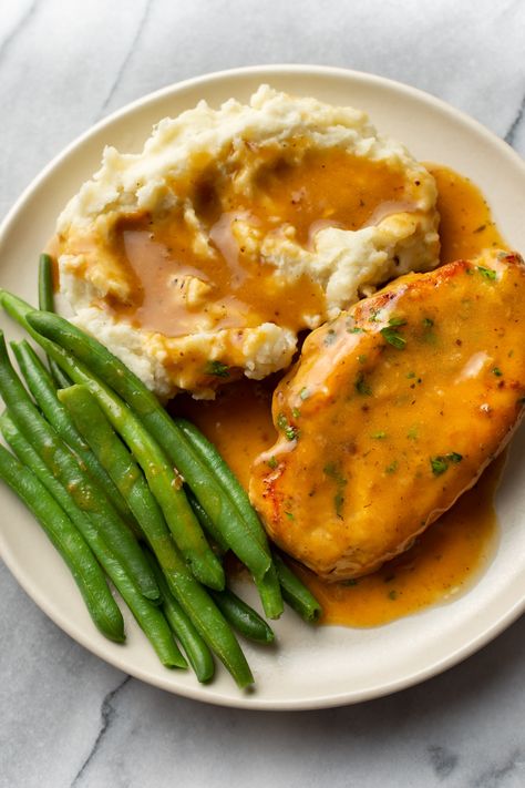 Tender chicken breasts are pan fried and smothered with a delicious, simple homemade gravy. Total comfort food that's perfect over mashed potatoes, pasta (try egg noodles), or rice. Chicken And Mash Recipes, Healthy Dinner Recipes With Mashed Potatoes, Chicken And Gravy Dinner Ideas, Mashed Potatoes And Chicken Recipe, Chicken Mashed Potatoes Green Beans, Chicken With Mashed Potatoes And Gravy, Chicken Recipes That Go With Mashed Potatoes, Mash And Gravy Dinners, Mash Potato Meals Dinners