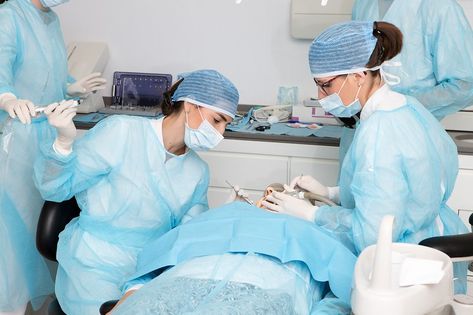 Female doctor taking tool from crop assistant while treating teeth of client with colleague during work in modern clinic Modern Clinic, Nurse Aesthetic, Female Doctor, Surgery, Quick Saves