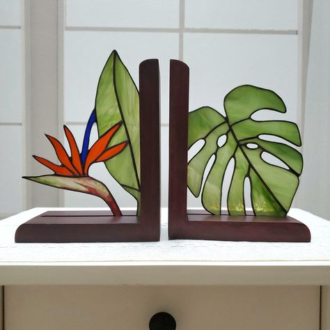 Handmade Stained Glass Monstera and Bird of Paradise Bookends. Features whispy green, bright orange and blue glass. Metal is finished with a black patina and polished to a shine. Wooden frames each measure 7x6" and are finished with a mahogany stain. Please allow for slight variations in glass colors and textures as each set will be completely one of a kind.  All items in my shop are handmade by me in my home studio. Please message for custom inquiries.  ‼️Allow appx 2 weeks for production‼️ Ite Stained Glass Bookends, Stained Glass Monstera, Glass Book, Mahogany Stain, Stained Glass Flowers, Stained Glass Diy, Stained Glass Crafts, Book Gift, Stained Glass Designs