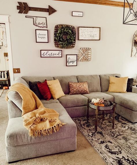 Silver metal and stained wood tray top side table used as a coffee table for gray sofa stands on a beige and black rug. Yellow, red and brown decorative pillows and a yellow throw blanket adorn the chaise lounge sofa. Beige And Red Living Room, Grey Farmhouse Living Room, Grey Leather Couch, Round Black Coffee Table, Grey Sectional Couch, Tufted Ottoman Coffee Table, Couch Designs, Light Gray Couch, Brown Decorative Pillows