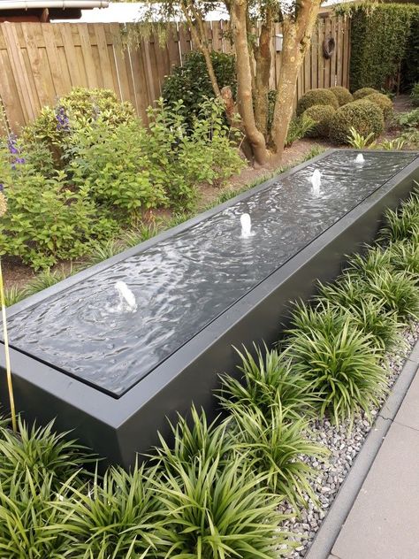 Enhance your home decor with the therapeutic sounds of flowing water, turning your patio, garden, or courtyard into a peaceful retreat. Create a visual masterpiece that not only captivates the eye but also calms the mind, making your outdoor space a haven for relaxation and rejuvenation. #OutdoorWaterfall #HomeDecorIdeas #GardenDesign #TranquilSpaces #WaterFeature #RelaxationHaven #OutdoorLiving #FountainDesign #NatureInspiredDecor #SerenityAtHome #LandscapingIdeas #ZenGarden #ModernLiving #Out Long Water Feature, Water Feature Against Wall, Simple Water Feature, Modern Pond Ideas, Backyard Water Feature Ideas, Waterfall Installation, Modern Water Fountain, Modern Pond, Garden Fancy